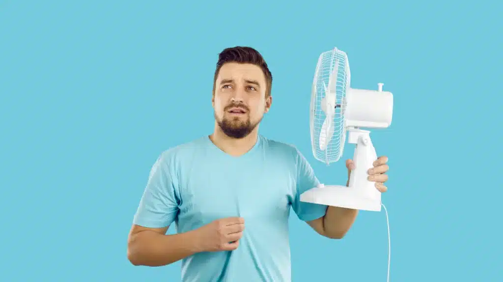 Man in blue shirt with fan in summer